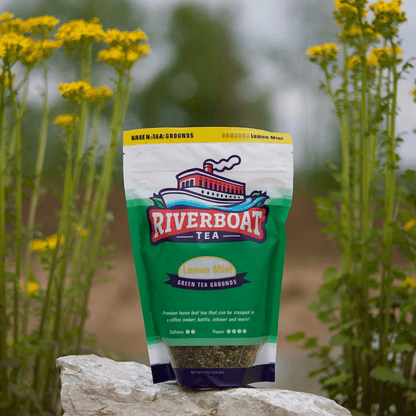 Riverboat Tea package on a rock with yellow flowers in the background