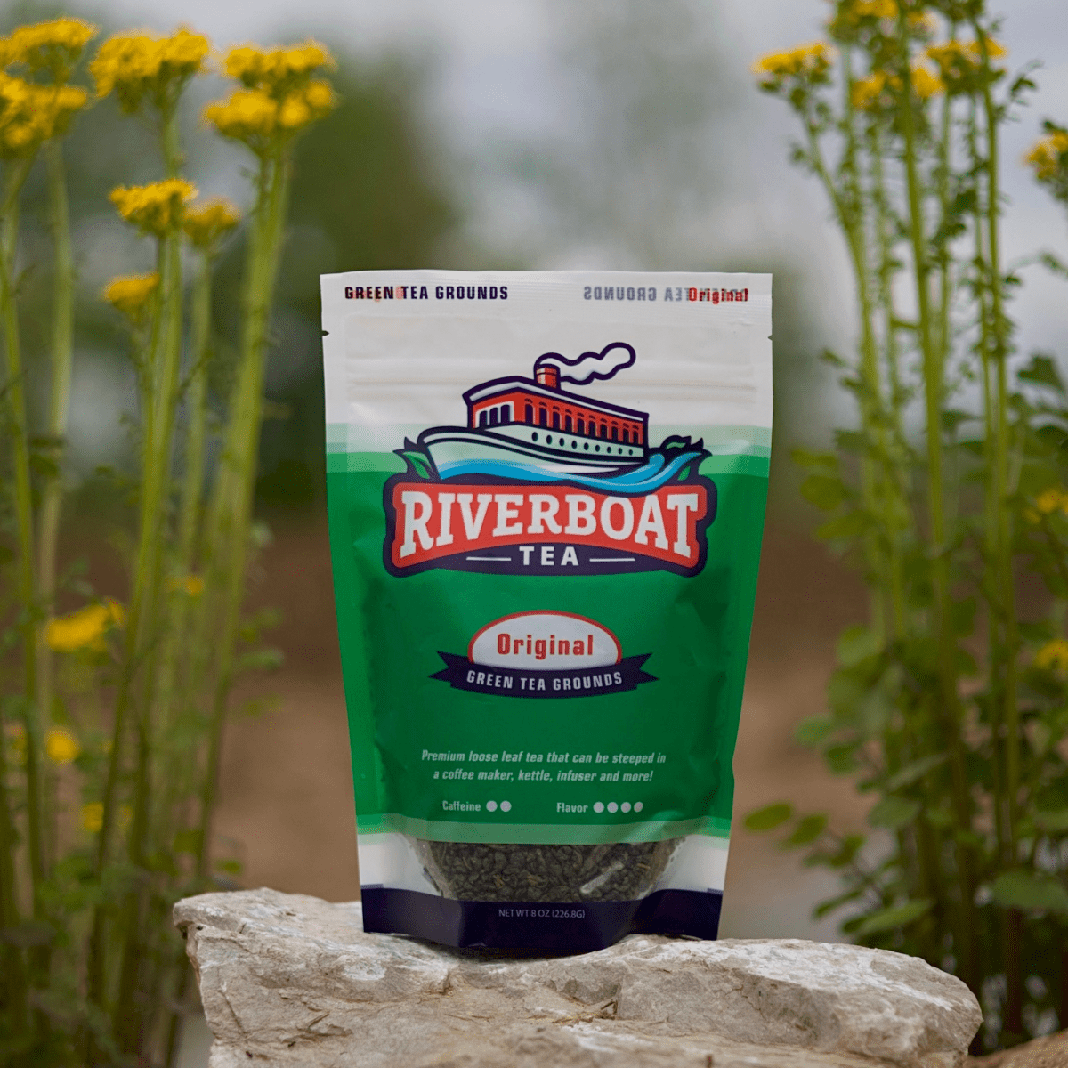 Riverboat Tea package on a rock with flowers in the background