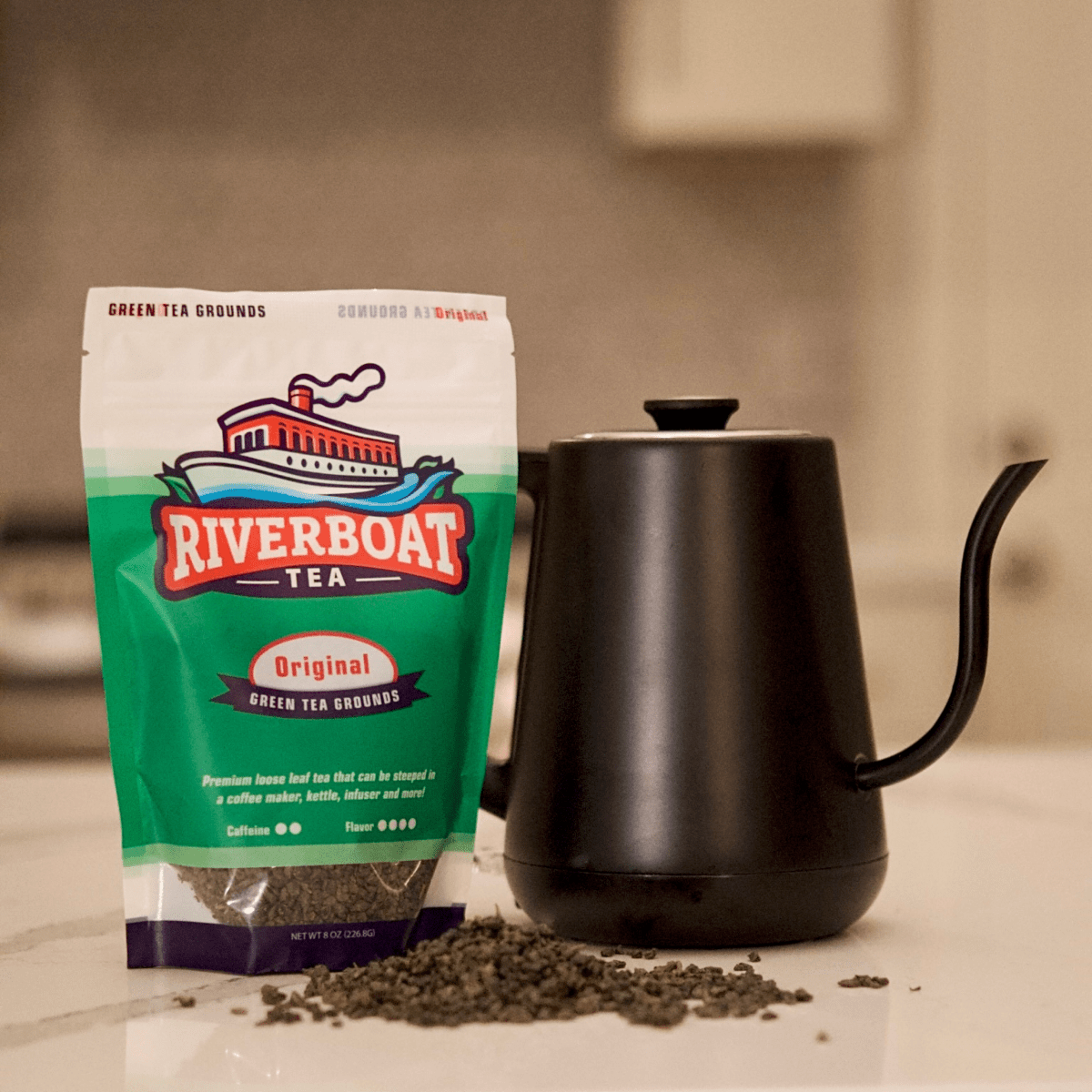 Riverboat Tea package with a black gooseneck kettle on a neutral background